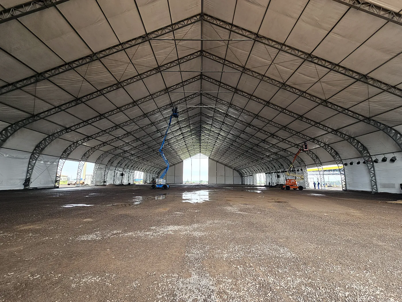 Interior da tenda já coberta, com plataformas elevatórias